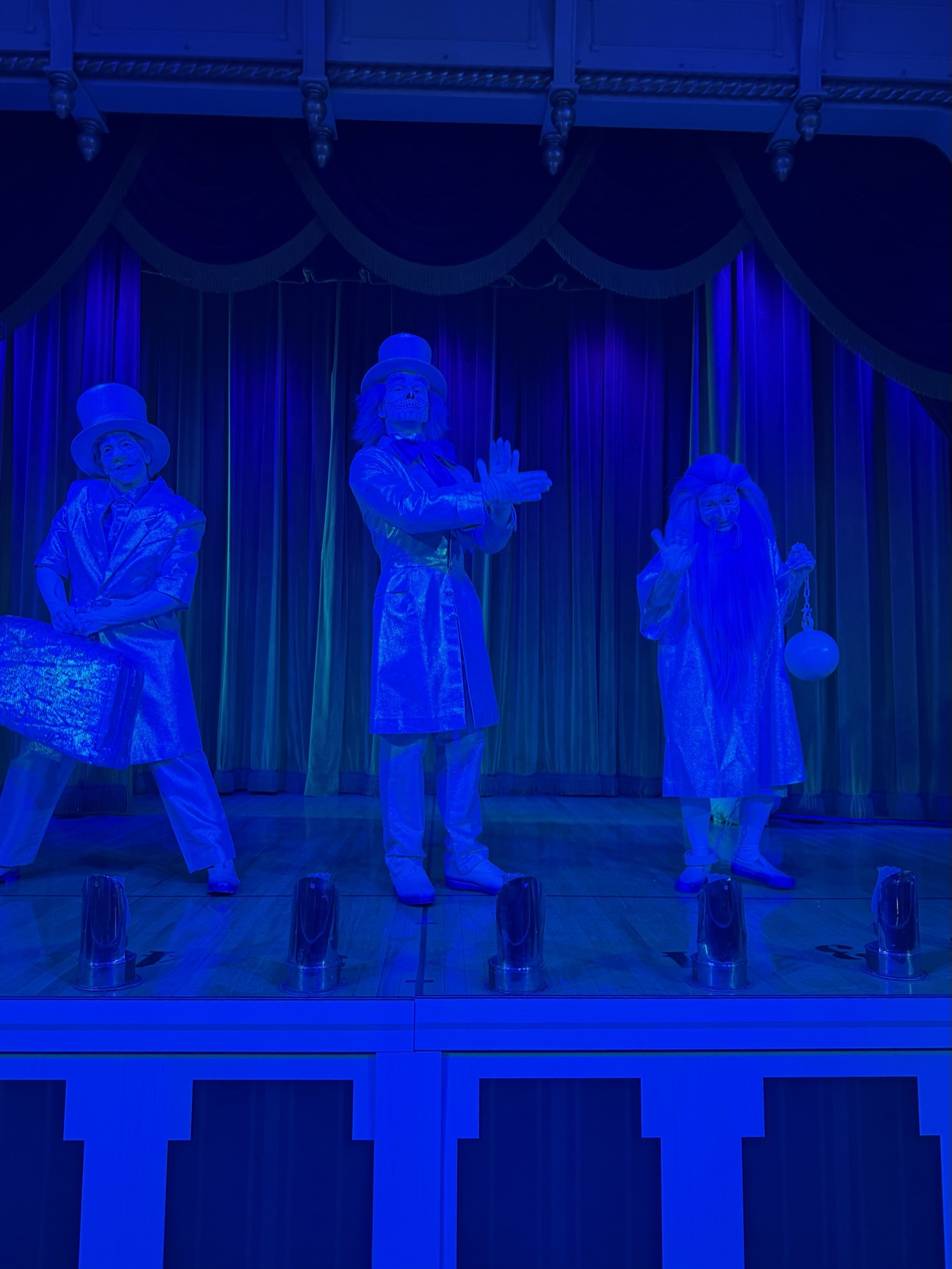 The Hitchhiking Ghosts greeting guests in eerie blue light — the rare characters only come out to play on party nights