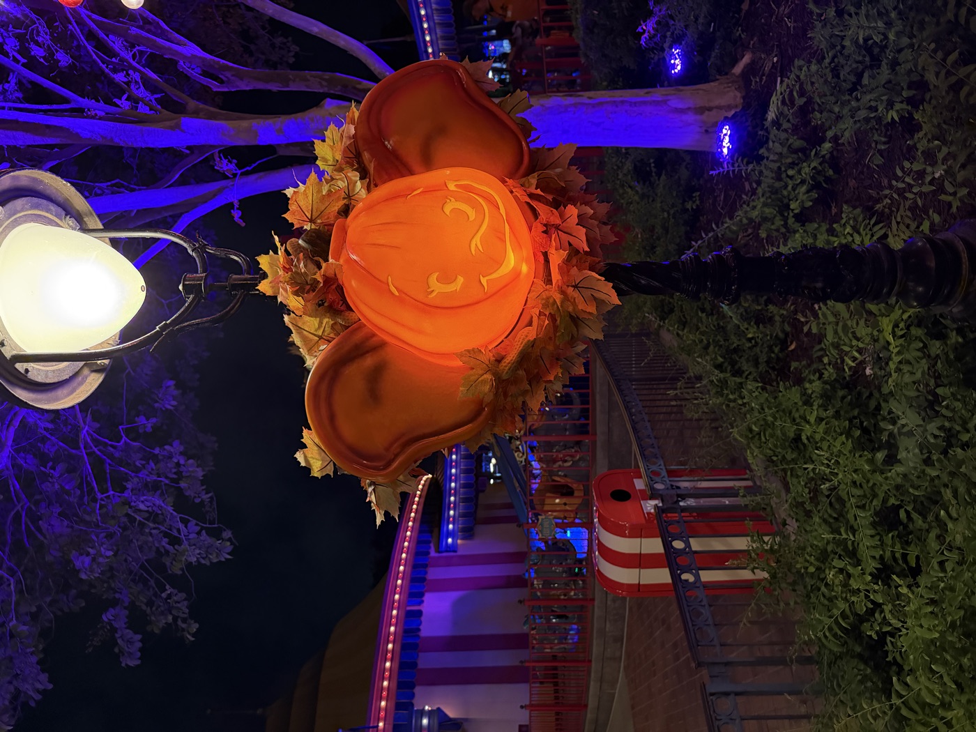 A grinning elephant jack-o-lantern with pumpkin ears glowing on a lamppost — the party decor goes all in